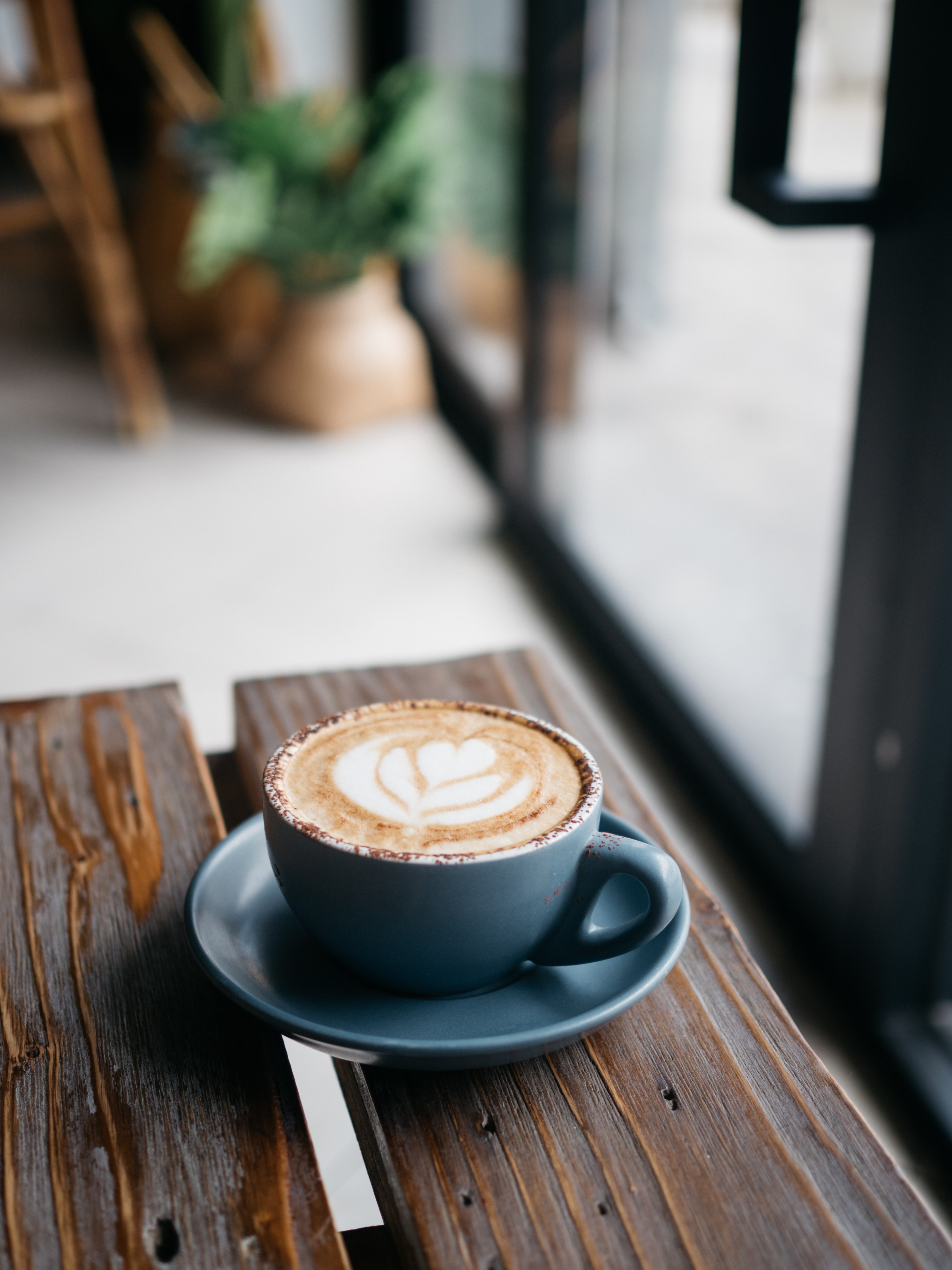 latte art on a small cup of coffee resting on a table