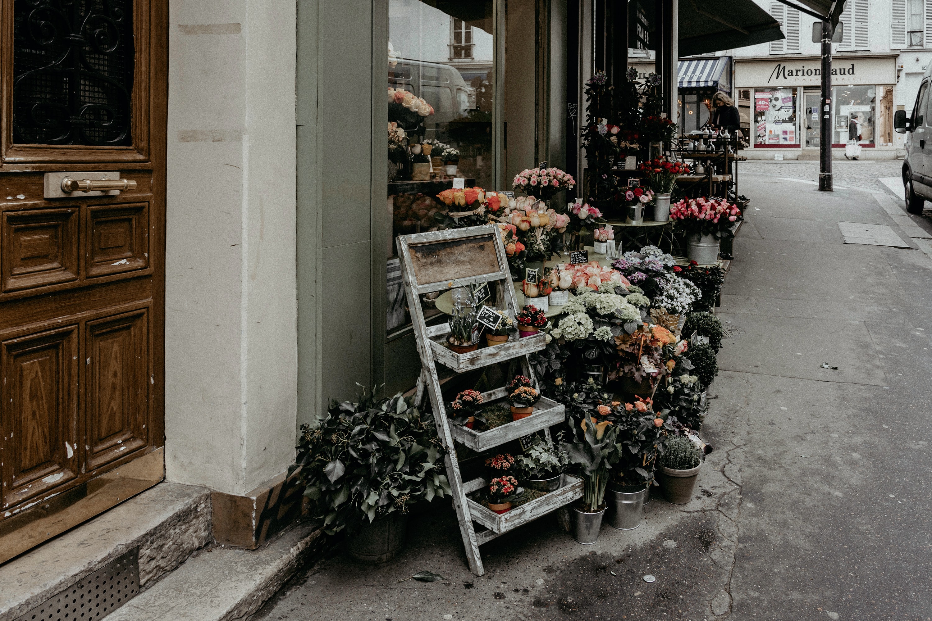 an outside view of a florist boutique with lots of bouquets and foliage